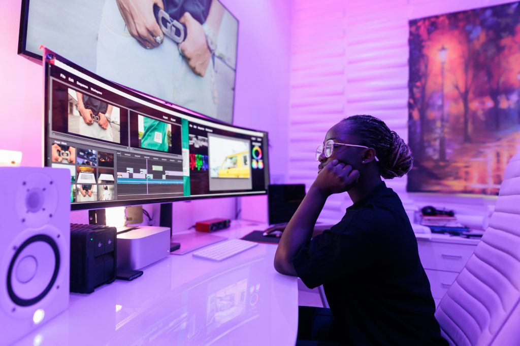 Someone sits at a desk looking at a computer 